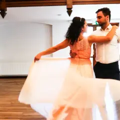 Para tańczy walca wiedeńskiego. Ona w zwiewnej, brzoskwiniowej sukni, on w eleganckiej koszuli.