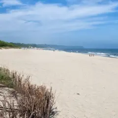 Plaża we Władysławowie, idealne miejsce na wypoczynek. Piasek, morze i zielone wydmy tworzą piękne krajobrazy, a liczne atrakcje czekają na turystów.
