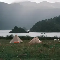 Namiotowe miasteczko nad jeziorem, mgliste góry w tle. Idealne miejsce na samotny wyjazd Polska.