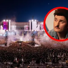 Gwiazda z wąsem na tle tłumu na największym koncercie w Polsce. Stadion wypełniony po brzegi, światła i dym tworzą niesamowitą atmosferę.