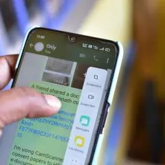 Palec dotyka ekranu telefonu, wybierając opcję "Screenshot", aby pokazać, jak zrobić screena.