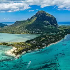 Rajska plaża na Mauritiusie, gdzie turkusowa woda i bujna zieleń zachęcają do relaksu. Pamiętaj o Mauritius szczepienia przed podróżą!