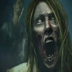 Przerażająca twarz zombie z zielonymi oczami i otwartymi ustami, w tle inny zombie. Scena jak z najlepszych filmów o zombie.