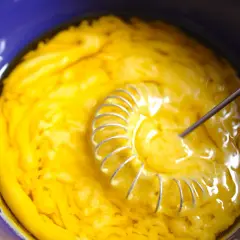 Gelbe Masse wird in blauer Schüssel mit Schneebesen verrührt. Das ist die Basis für eine leckere Vinaigrette.
