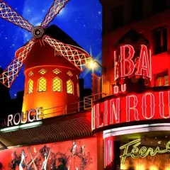 Le Moulin Rouge illuminé la nuit, avec son moulin rouge emblématique et ses néons. Le prix d'entrée pour ce spectacle légendaire est une invitation à la féerie.
