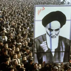 Massen jubeln bei der islamischen Revolution 1979 in Iran, ein riesiges Porträt von Ayatollah Khomeini wird hochgehalten.
