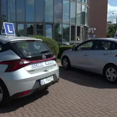 Dwa srebrne samochody z literą "L" na dachu i napisem "EGZAMIN WORD" na klapie bagażnika, gotowe do jazdy próbnej we Włocławku.