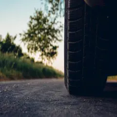 Opona samochodowa 235/40 r19 na drodze, w tle zieleń i niebo.