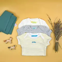 Trois bodies pour bébé avec des étiquettes personnalisées. Apprenez comment enlever une étiquette thermocollante pour réutiliser ces vêtements.