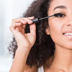 Une femme applique du mascara, ses cils s'allongent. Elle sourit, le mascara qui coule est évité.