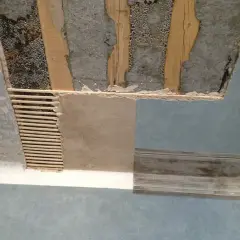 Soffitto in fase di ristrutturazione, con travi a vista e intonaco parzialmente rimosso. Si vede come rasare un soffitto rovinato, con listelli di legno e nuovo intonaco.