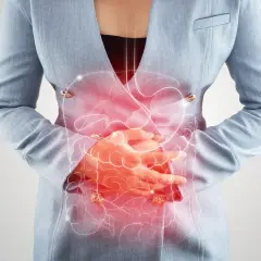 Frau hält sich den schmerzenden Bauch, rote Darstellung des Verdauungstrakts. Mögliche bauchfellentzündung symptome.