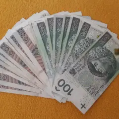 Stos banknotów 100 i 200 zł, miły gest - darowizna od brata.