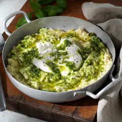 En skål med pasta som ser ut som ris, toppad med krämig burrata och grön pesto. En utsökt rätt som ser ut att vara gjord med kärlek.