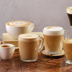 Vielfalt an Kaffee Kreationen: Latte Art, Espresso und cremige Cappuccinos in verschiedenen Tassen und Gläsern.