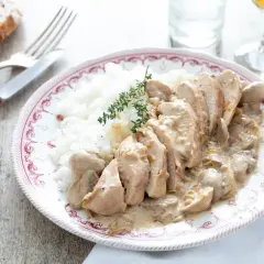 Délicieuse recette filet de poulet à la crème et champignons, servi avec du riz blanc et garni de thym frais.