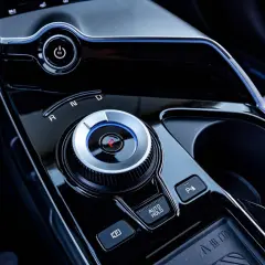Pokrętło wyboru biegów w nowoczesnym samochodzie z napędem elektrycznym. Widoczny przycisk EV i oznaczenia R, N, D. Skrzynia biegów automat ułatwia jazdę.