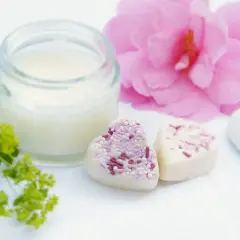 Słoiczek z kremem, serduszka z posypką i różowa piwonia. Krem zawiera caprylic capric triglyceride, składnik nawilżający.
