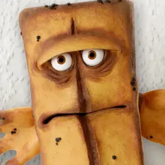Smutny Bernd das Brot, z wielkimi oczami i wyrazem twarzy pełnym zmartwienia, stoi na tle chropowatej ściany.