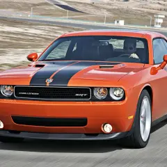 Pomarańczowy Dodge Challenger SRT na torze wyścigowym. Poznaj jego dodge challenger dane techniczne i poczuj moc!