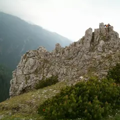 Sarnia skała szlak w Tatrach. Grupa turystów na szczycie skalistego wzniesienia, podziwiająca mgliste pasmo górskie.