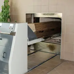 Wózek z trumną wjeżdża do pieca kremacyjnego. Proces ten nie powoduje bólu, jest to ostatnie pożegnanie.