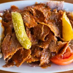 Pyszny kebab z mięsa mielonego, podany z ryżem, jogurtem, pomidorem i pikantną papryczką.