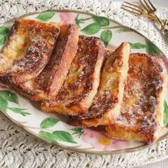 Torrijas doradas y crujientes, espolvoreadas con azúcar, recién salidas de la freidora de aire. ¡Un placer casero!