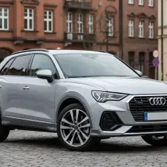 Srebrne Audi Q3 na brukowanej ulicy. Sprawdź atrakcyjną audi q3 cena i wybierz swój wymarzony SUV.