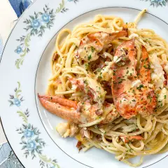 Délicieux spaghetti aux morceaux de homard, nappés d'une sauce crémeuse et parsemés de ciboulette. Un plat de pâtes au homard qui fait rêver.