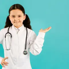 Mała lekarka z uśmiechem prezentuje wiedzę, odpowiadając na pytanie: czy autyzm jest wyleczalny?