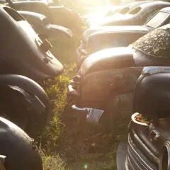 Rottami d'auto d'epoca al tramonto. Chissà quanto costa rottamare un'auto così, tra ruggine e ricordi.