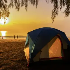 Namiot na plaży o zachodzie słońca. Idealne miejsce na tanie kempingi nad morzem, gdzie można podziwiać piękno natury.
