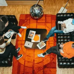 Fyra personer jobbar på sina laptops i en kreativ miljö i Stockholm. En glittrig discokula hänger ovanför.