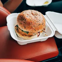 Pyszny burger w białym pudełku, idealny na szybki posiłek w podróży. Nie martw się o wieśmac kcal, ciesz się smakiem!