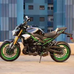 Kawasaki Z900 negra y gris con detalles verdes vibrantes. Su peso ligero y diseño agresivo la hacen ideal para la ciudad.