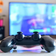 Czarny pad DualShock 4 na białym blacie, gotowy do gry na PC. Dowiedz się, jak podłączyć pada PS4 do PC, by cieszyć się grami na większym ekranie.