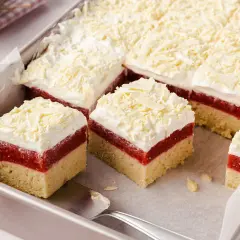 Schichtkuchen mit roter Fruchtschicht, weißer Creme und Schokostreuseln, wie von Frau Holle gebacken.