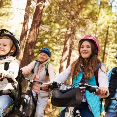 Familie genießt einen sonnigen tagesausflug mit oma und opa auf Fahrrädern im Wald.