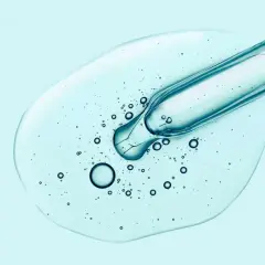 Tropfen Hyaluron-Serum aus Pipette auf hellblauem Hintergrund. Hilft gegen Pickel und spendet Feuchtigkeit.