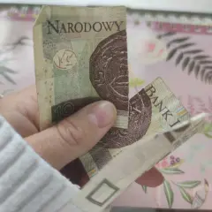 Dłoń trzyma sklejony banknot 10 zł. Zastanawiasz się, co zrobić ze sklejonym banknotem?