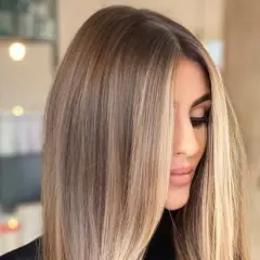 Kobieta z pięknymi, długimi, **front blond** włosami, delikatnie opadającymi na twarz.