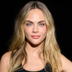 Cara Delevingne mit blondem, leicht plattem Haar und blauen Augen.