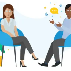 A man and woman sit in chairs, discussing. A speech bubble and thumbs-up icons suggest they are learning how to give feedback effectively.
