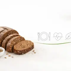 Krojony chleb żytni z ziarnami i kłosami. Ikony symbolizują zdrowie i dietę, sugerując, czy chleb żytni jest zdrowy.