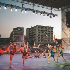 Atleti in posa sul palco di Riccione, un'esibizione di ginnastica ritmica che incanta il pubblico.