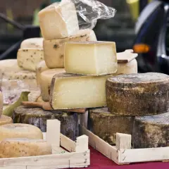 Un étalage de fromages variés, dont un beau fromage parisien, empilés et prêts à être dégustés.
