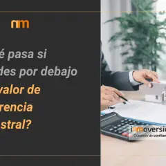 ¿Qué pasa si vendes por debajo del valor de referencia catastral? Agentes inmobiliarios negocian una casa en miniatura sobre un contrato.