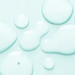 Gocce trasparenti su sfondo azzurro. Alcuni si chiedono se il cocamidopropyl betaine fa male, ma questa immagine mostra solo liquidi puri.
