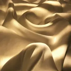 Sanfter Glanz auf gewaschenem Satin. Die Falten des Stoffes werfen weiche Schatten und erzeugen ein Gefühl von Luxus und Ruhe.